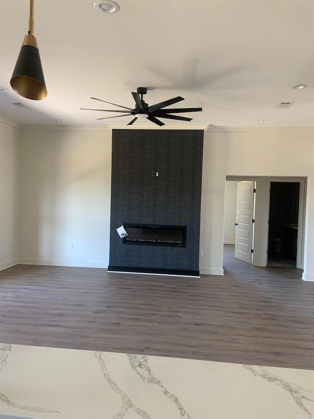 unfurnished living room featuring dark wood-type flooring, crown molding, and ceiling fan