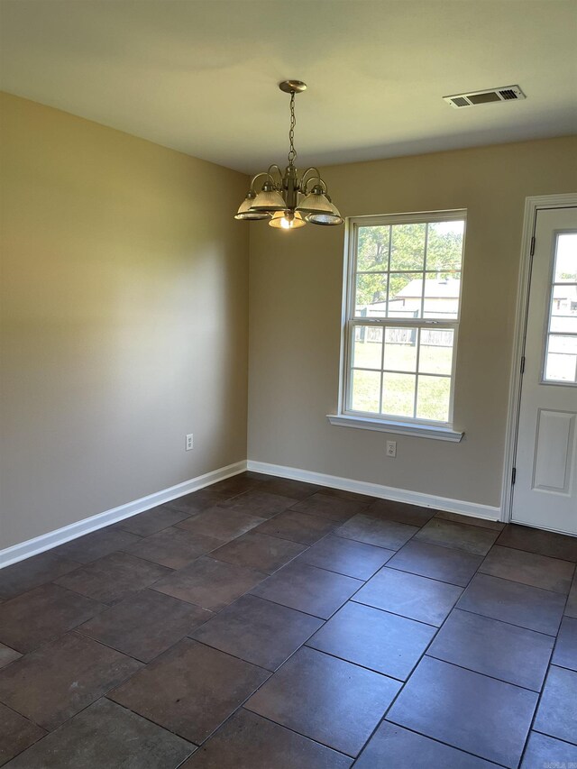 unfurnished room with a notable chandelier