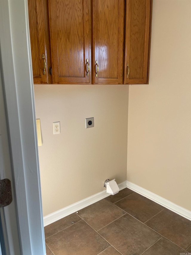 laundry room with cabinets, dark tile patterned flooring, and hookup for an electric dryer