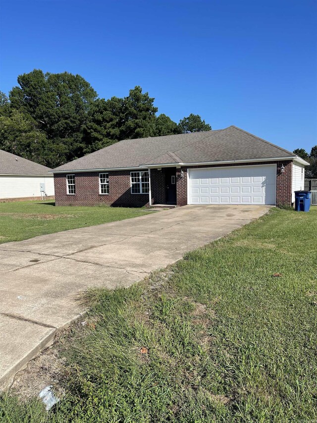 single story home with a garage and a front lawn