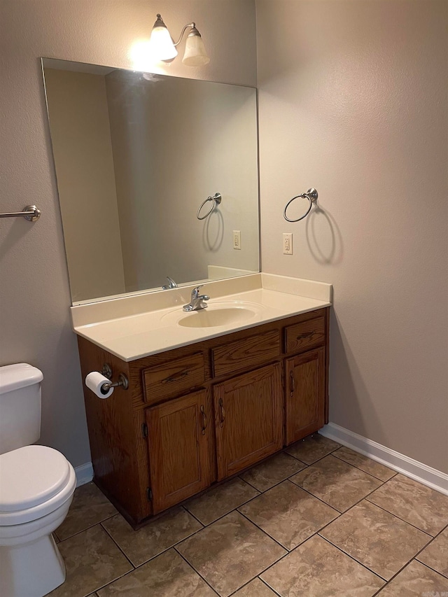 bathroom featuring tile patterned flooring, vanity, and toilet