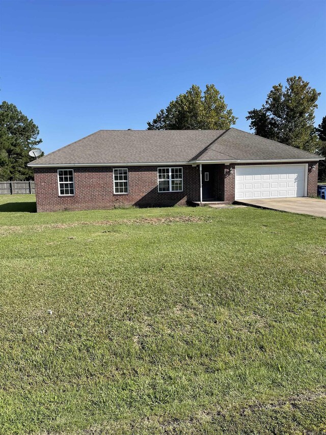 ranch-style home featuring a garage and a front lawn