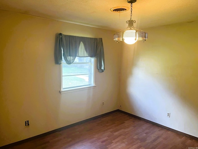 spare room with wood-type flooring and a textured ceiling