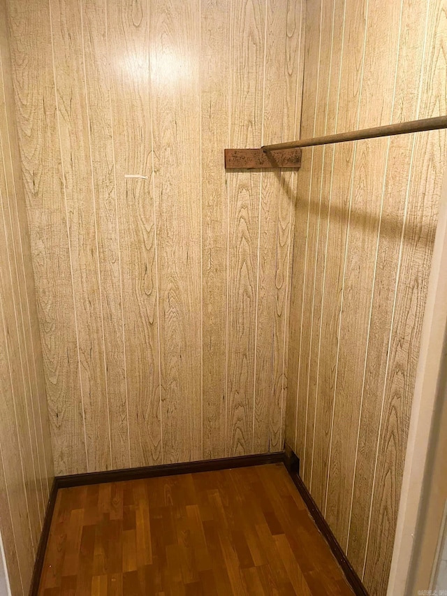 walk in closet with dark hardwood / wood-style flooring