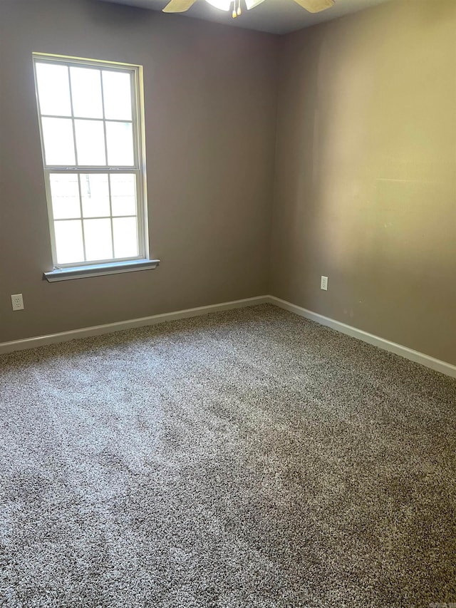 carpeted spare room featuring ceiling fan