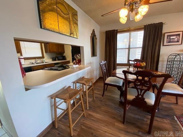 dining room with ceiling fan, dark hardwood / wood-style floors, and sink