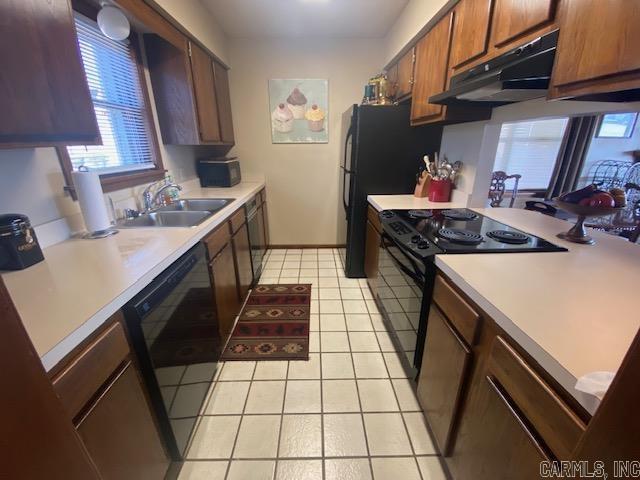 kitchen featuring light tile patterned floors, sink, and black appliances