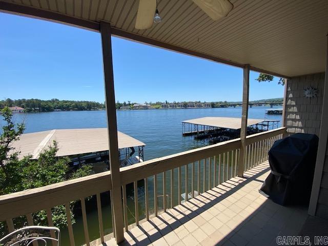 balcony featuring a water view and ceiling fan