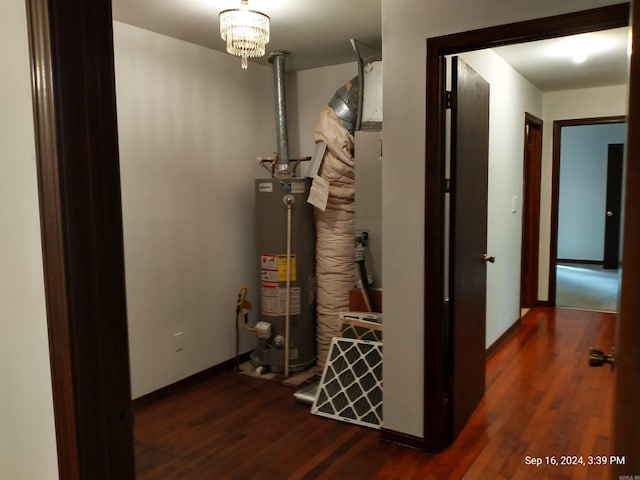 hall with gas water heater, dark hardwood / wood-style flooring, and a chandelier