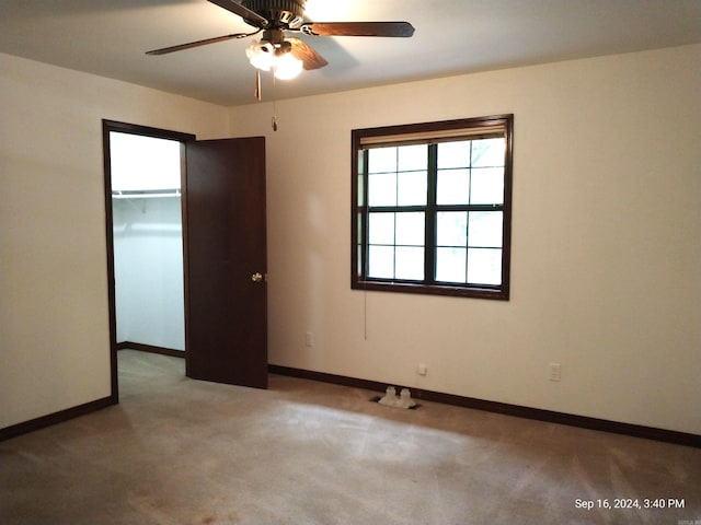 empty room featuring ceiling fan and light colored carpet