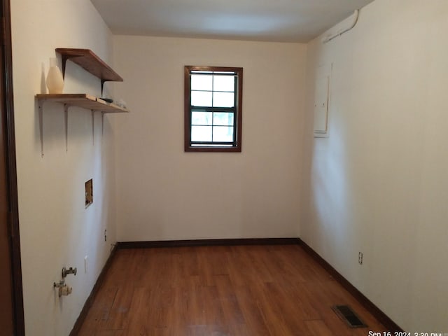 empty room with electric panel and hardwood / wood-style floors