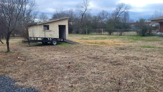 view of yard with a garage and an outbuilding