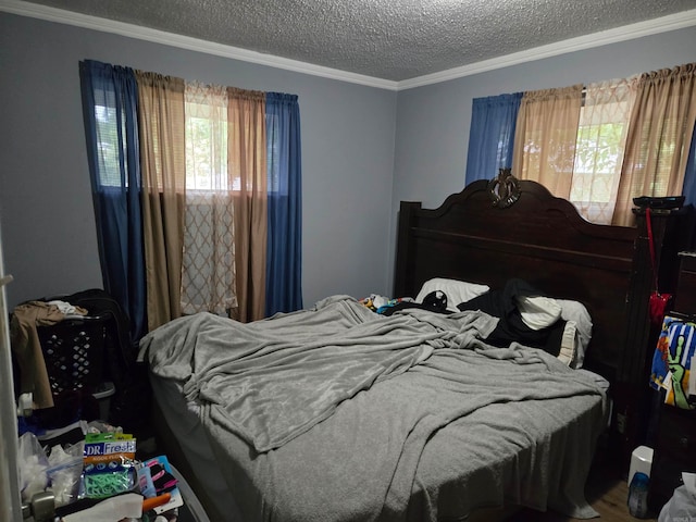 bedroom with ornamental molding, wood-type flooring, and a textured ceiling