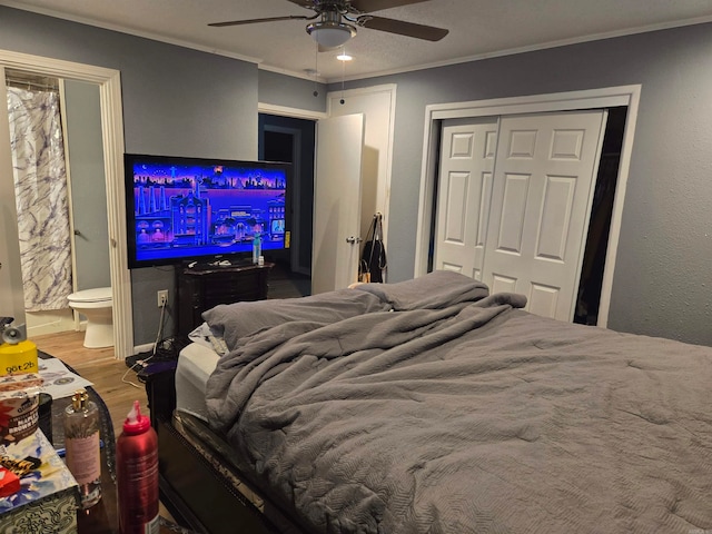 bedroom featuring a closet, ceiling fan, ensuite bathroom, hardwood / wood-style flooring, and bar