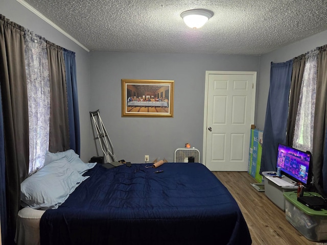 bedroom with a textured ceiling and hardwood / wood-style flooring