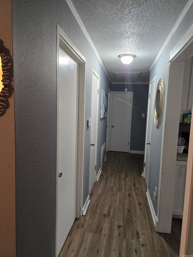 hall with a textured ceiling, ornamental molding, and dark hardwood / wood-style flooring