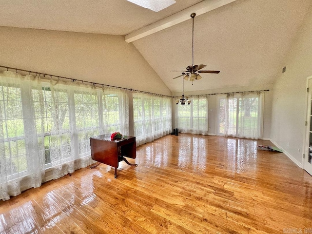 unfurnished sunroom with vaulted ceiling with skylight and ceiling fan