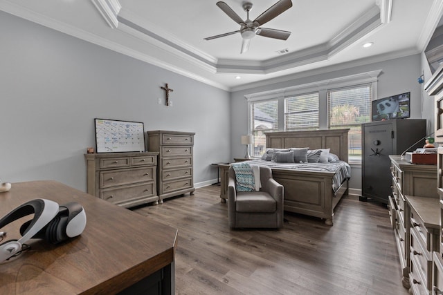 bedroom featuring ceiling fan, a raised ceiling, dark hardwood / wood-style floors, and crown molding