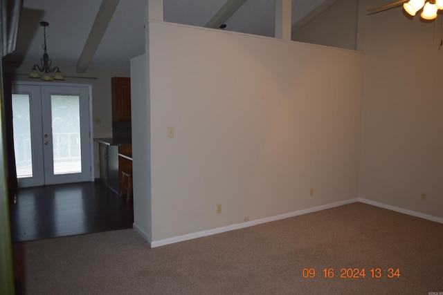 unfurnished room with french doors, lofted ceiling with beams, ceiling fan with notable chandelier, and carpet