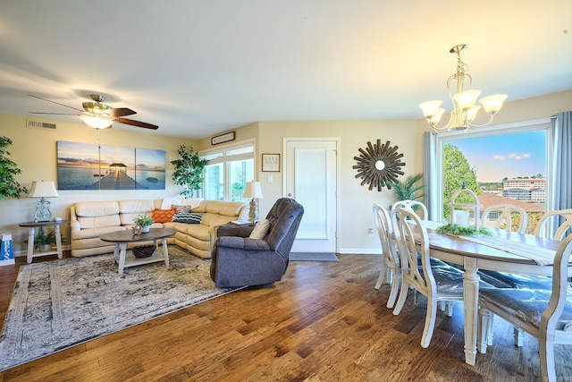 dining room with ceiling fan with notable chandelier and dark wood-type flooring