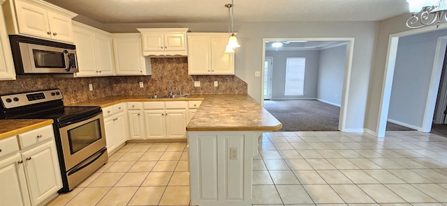 kitchen featuring stainless steel appliances, white cabinetry, light tile patterned flooring, and sink