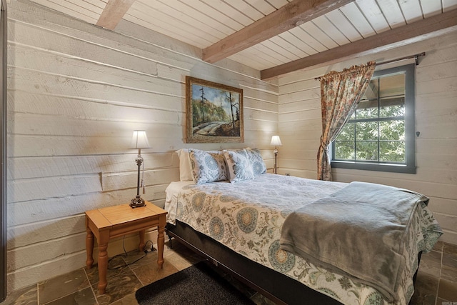 bedroom with beam ceiling, wood ceiling, and wood walls