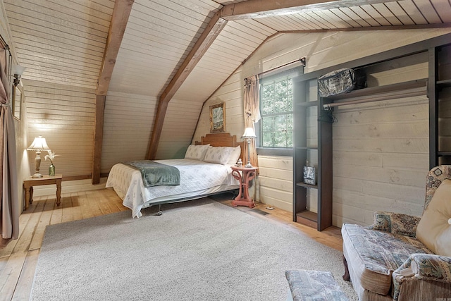 bedroom featuring vaulted ceiling with beams, light hardwood / wood-style flooring, wood walls, and wooden ceiling