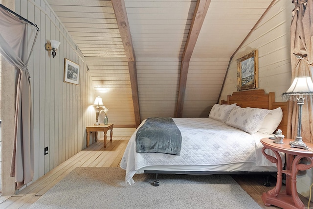 bedroom with light wood-type flooring, vaulted ceiling with beams, wood ceiling, and wooden walls