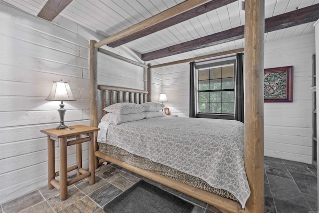 bedroom with wooden ceiling, wood walls, and beamed ceiling