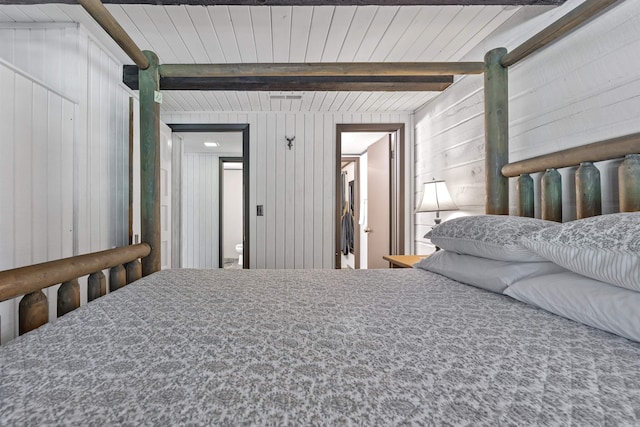 bedroom with carpet, wooden walls, beam ceiling, and wood ceiling