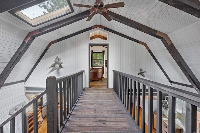 interior space featuring lofted ceiling with skylight, wood walls, and hardwood / wood-style flooring