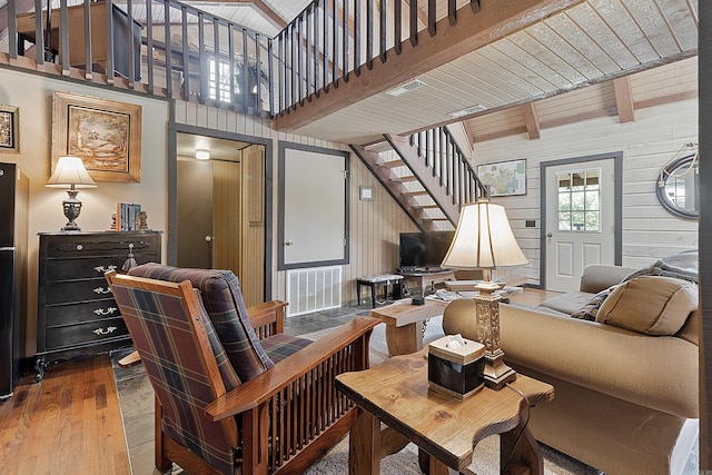 living room featuring wood ceiling, wooden walls, beam ceiling, and hardwood / wood-style floors