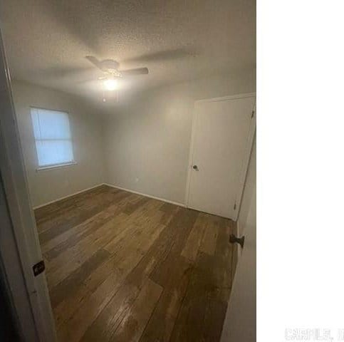 empty room featuring a textured ceiling, dark hardwood / wood-style floors, and ceiling fan