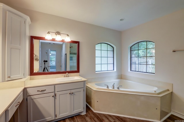 bathroom with independent shower and bath, vanity, and hardwood / wood-style floors