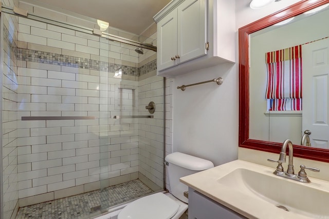 bathroom with vanity, toilet, and tiled shower