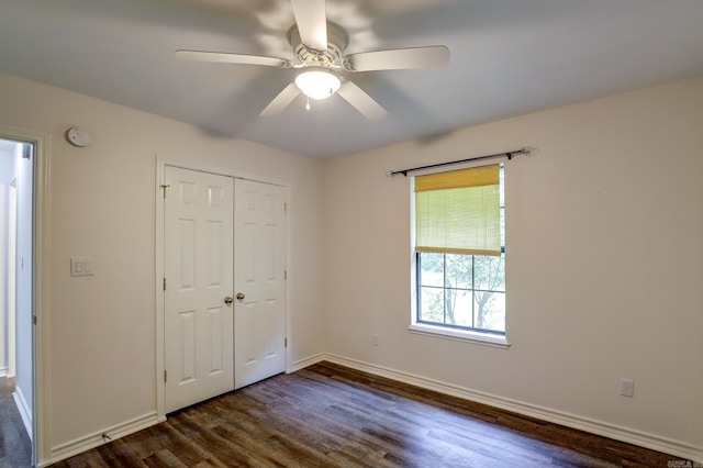 unfurnished bedroom with ceiling fan, a closet, and dark hardwood / wood-style floors