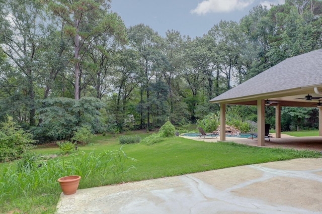 view of yard with ceiling fan and a patio area