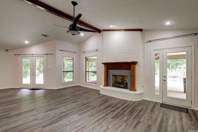 unfurnished living room with hardwood / wood-style floors, lofted ceiling with beams, a large fireplace, and ceiling fan