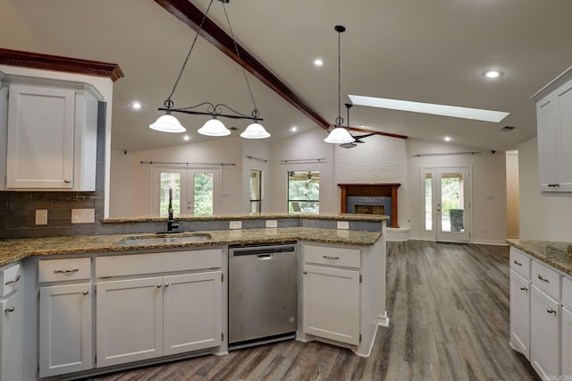 kitchen featuring white cabinetry, dishwasher, lofted ceiling with skylight, french doors, and sink