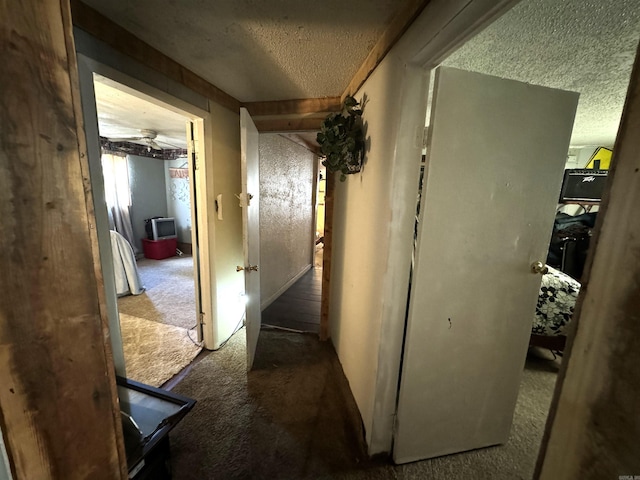 hall featuring a textured ceiling and carpet floors