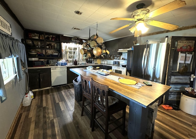 kitchen featuring dark hardwood / wood-style flooring, ceiling fan with notable chandelier, a kitchen island, white appliances, and crown molding