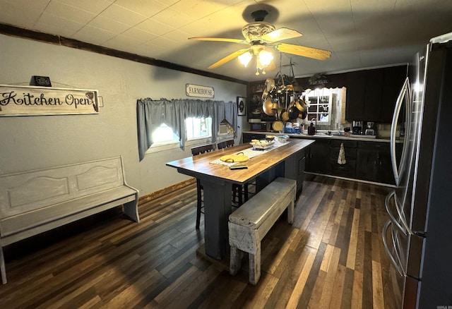 kitchen with ceiling fan with notable chandelier, butcher block counters, stainless steel refrigerator, dark hardwood / wood-style flooring, and ornamental molding