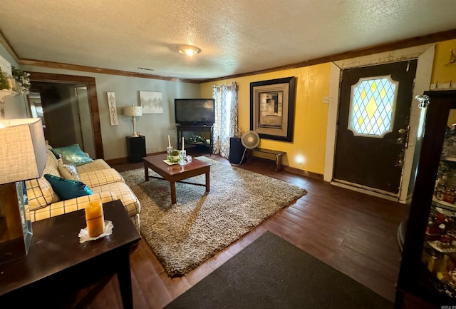 living room featuring a textured ceiling, ornamental molding, and dark hardwood / wood-style flooring