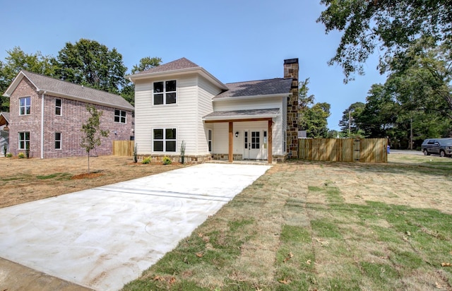 view of front of property with a front yard and french doors