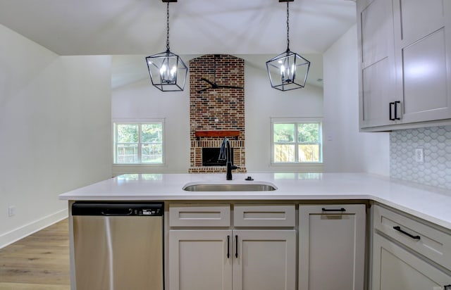 kitchen featuring a healthy amount of sunlight, hanging light fixtures, stainless steel dishwasher, and sink