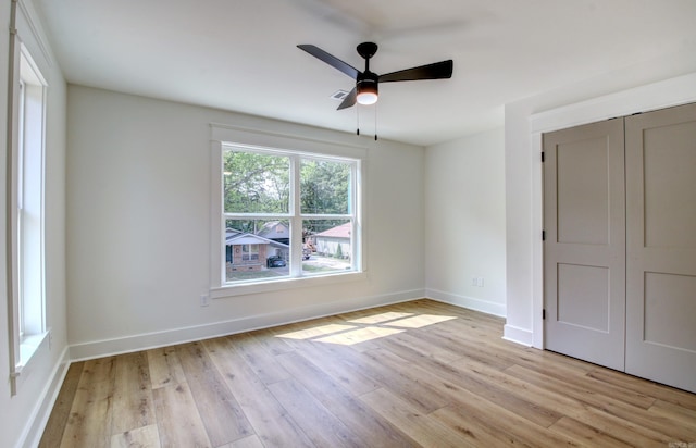 unfurnished bedroom featuring light hardwood / wood-style floors, ceiling fan, and a closet