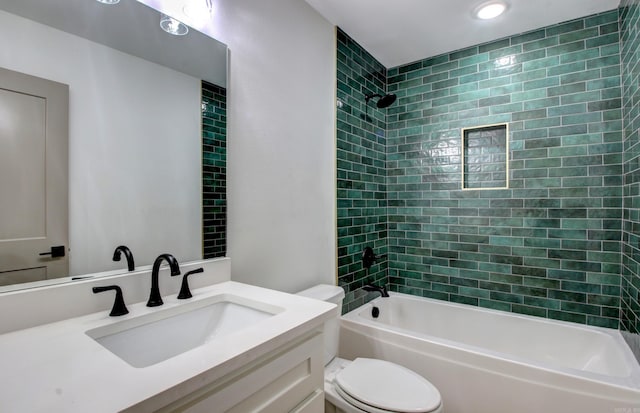 full bathroom with vanity, tiled shower / bath, and toilet