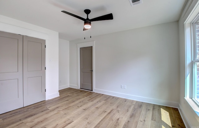 unfurnished bedroom with ceiling fan, light hardwood / wood-style flooring, and a closet