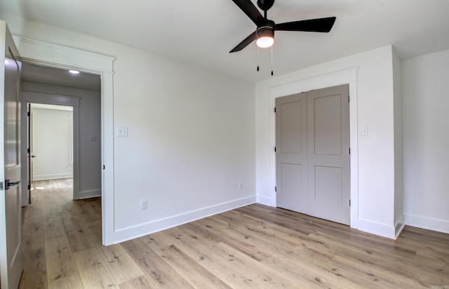 unfurnished bedroom with ceiling fan, light hardwood / wood-style flooring, and a closet