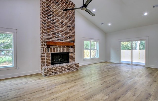 unfurnished living room with high vaulted ceiling, ceiling fan, light hardwood / wood-style flooring, and a fireplace